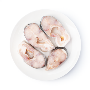 Four raw fish steaks arranged on a white plate, ready for cooking/serving.