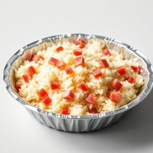 Aluminum pan filled with white rice studded with small red bell pepper cubes, a simple side dish image.