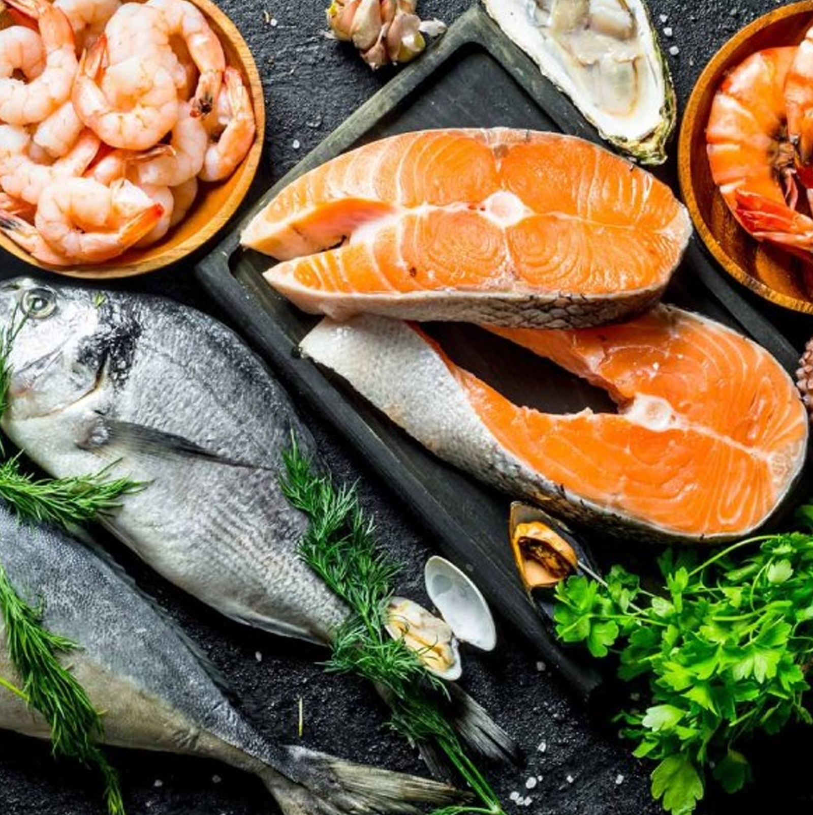 Fresh Seafood Choose from available fish Beef stew in a foil tray with potatoes and parsley garnish on a marble surface.